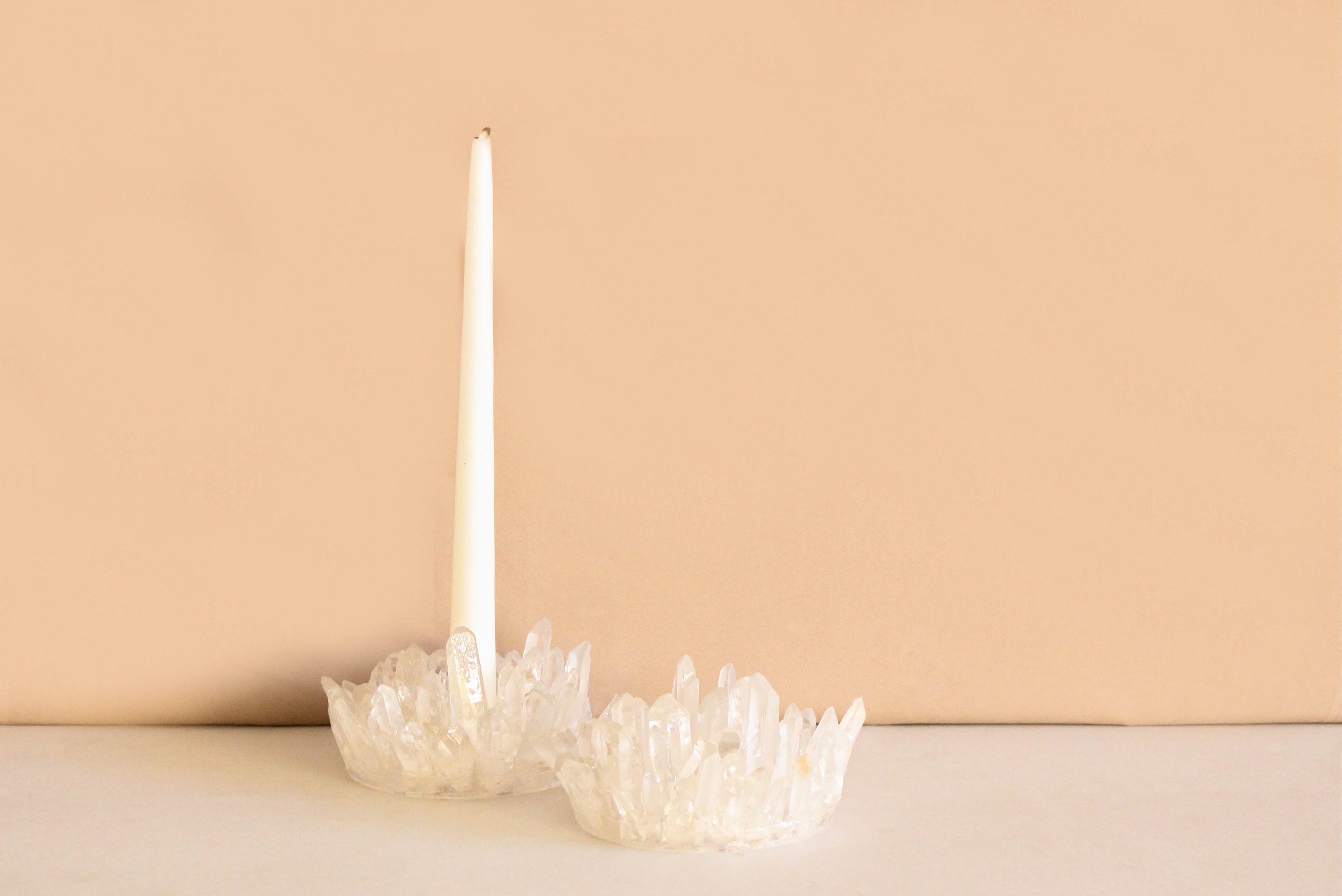 White Lemurian quartz points candle holder on a beige background